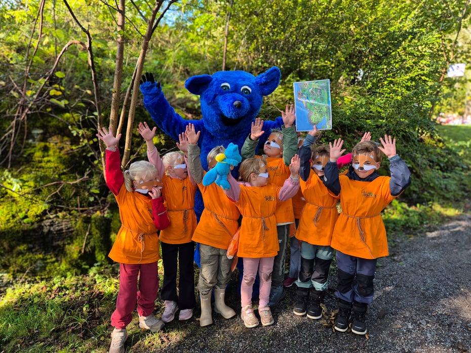 Barn og en maskot som jubler