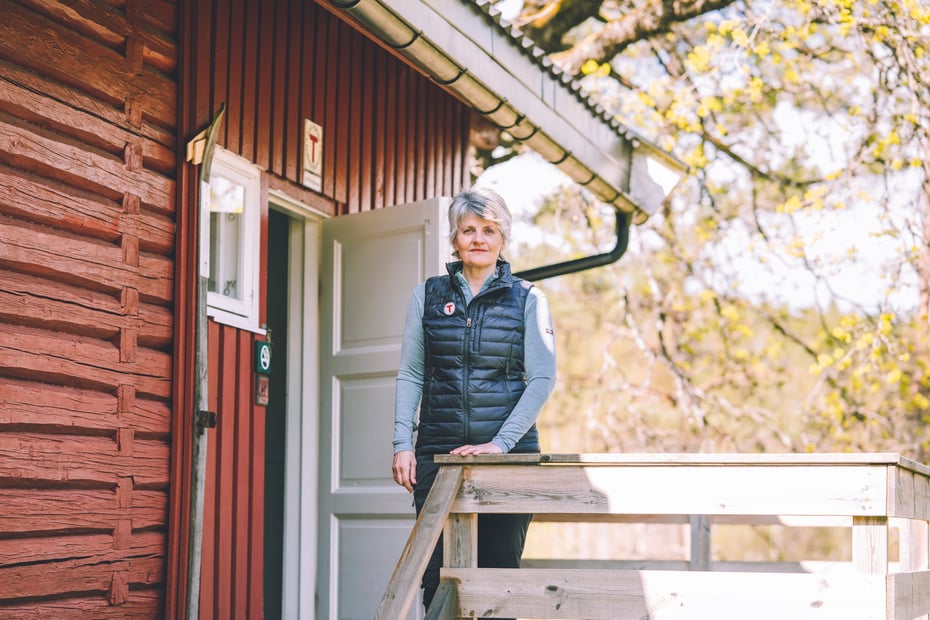Portrett av Inger Lise Blyverket utenfor en rødmalt DNT-hytte
