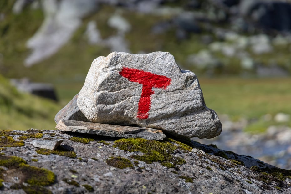 Varde med rød T på fjell.