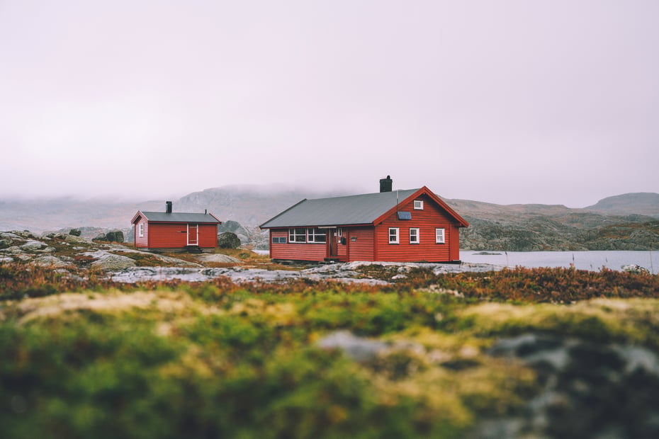 Krossvatn. 2 røde hytter . Den ene er litt mindre enn den andre. Det er grått vær. Typisk høst.
