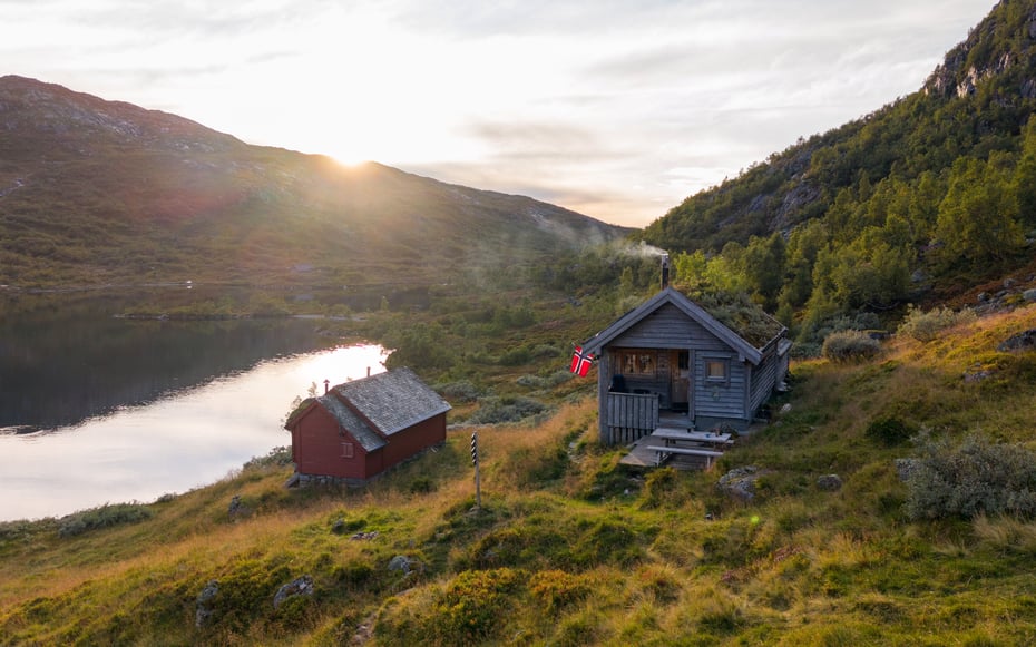 Hytte med røyk ut av pipen i høstfjellet.