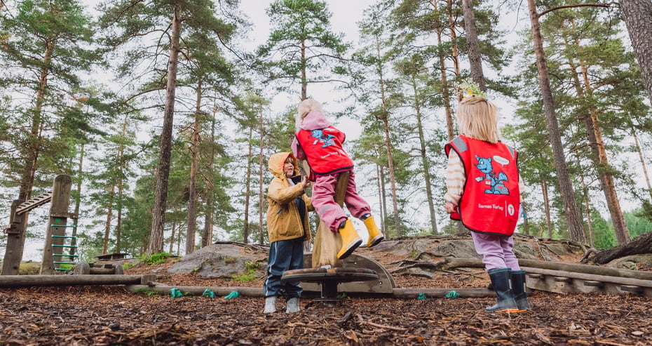 Barn som leker i skogen.