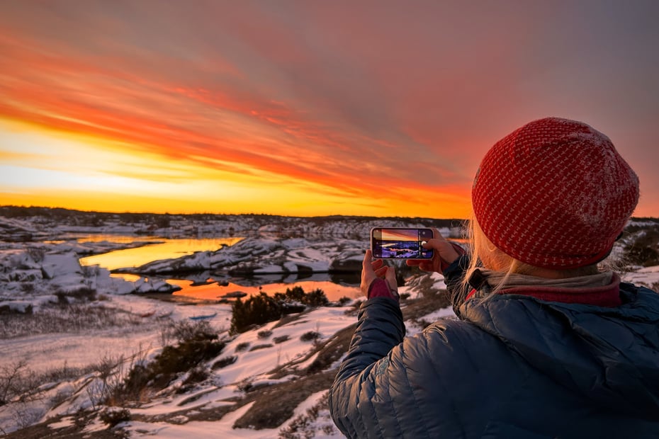 Kvinne med rød topphue ser utover landskap