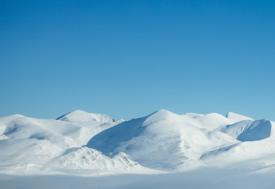 Snødekte fjelltopper og blå himmel