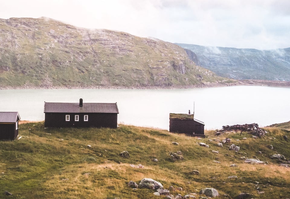 Fire hytter som ligger ved en innsjø