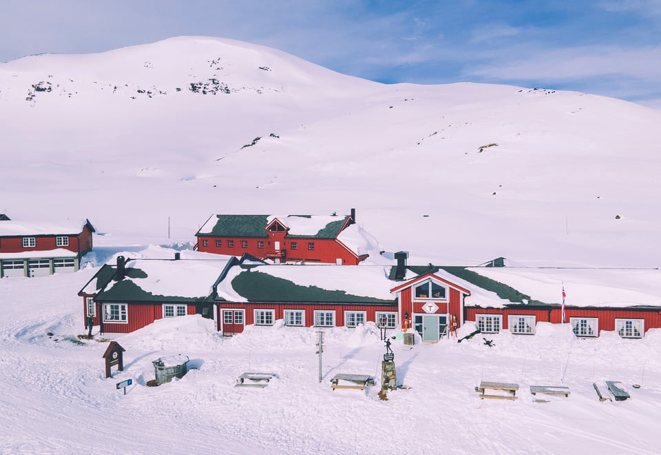 Rød hytte i vinterfjellet.