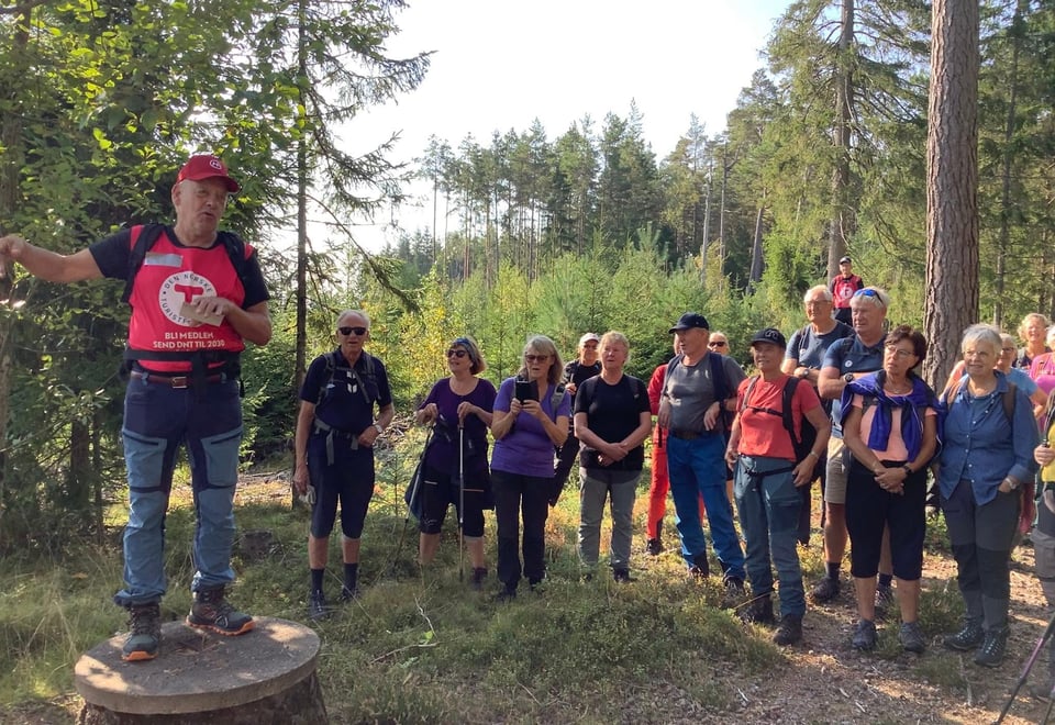 Turleder Knut Ivar Talberg i rød DNT-vest sammen med en gruppe turdeltagere. 