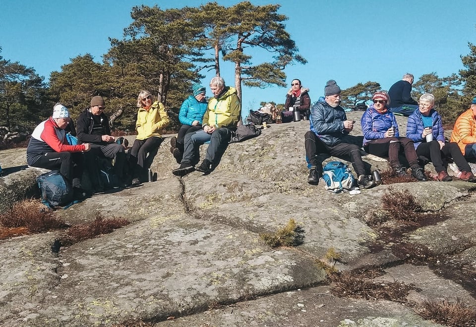 En turgruppe som spiser matpakkene sine på tur.