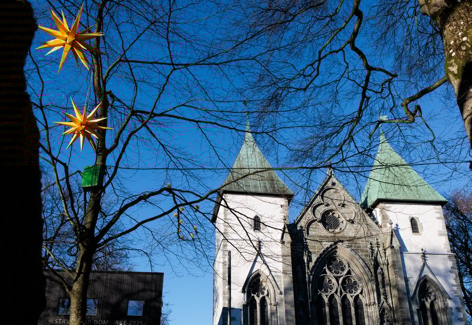 Hvit kirke og stjerner med blå himmel bak. 