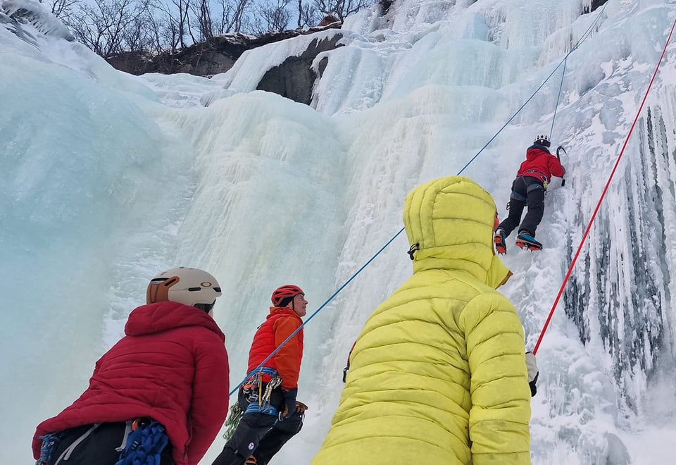 Kursdeltagere som klatrer i et islagt fossefall