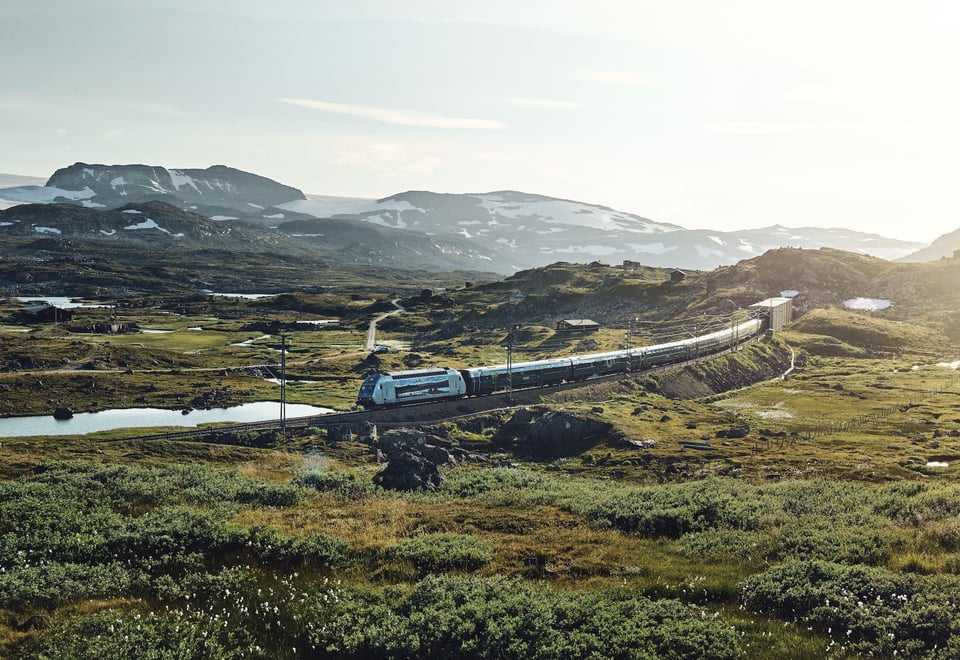 Tog som kjører gjennom fjellandskap