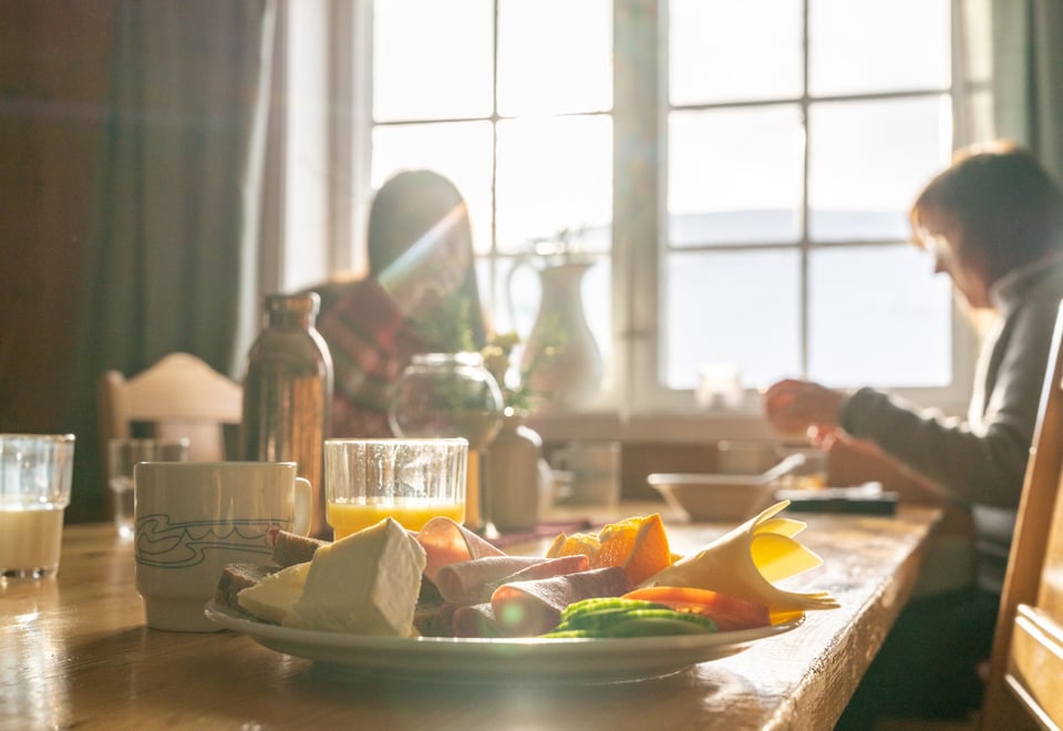 2 kvinner spiser frokost på gården