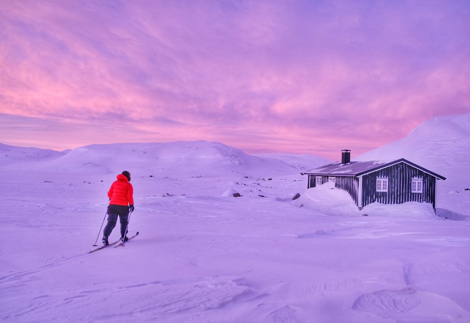 Person på skitur på vei mot en hytte