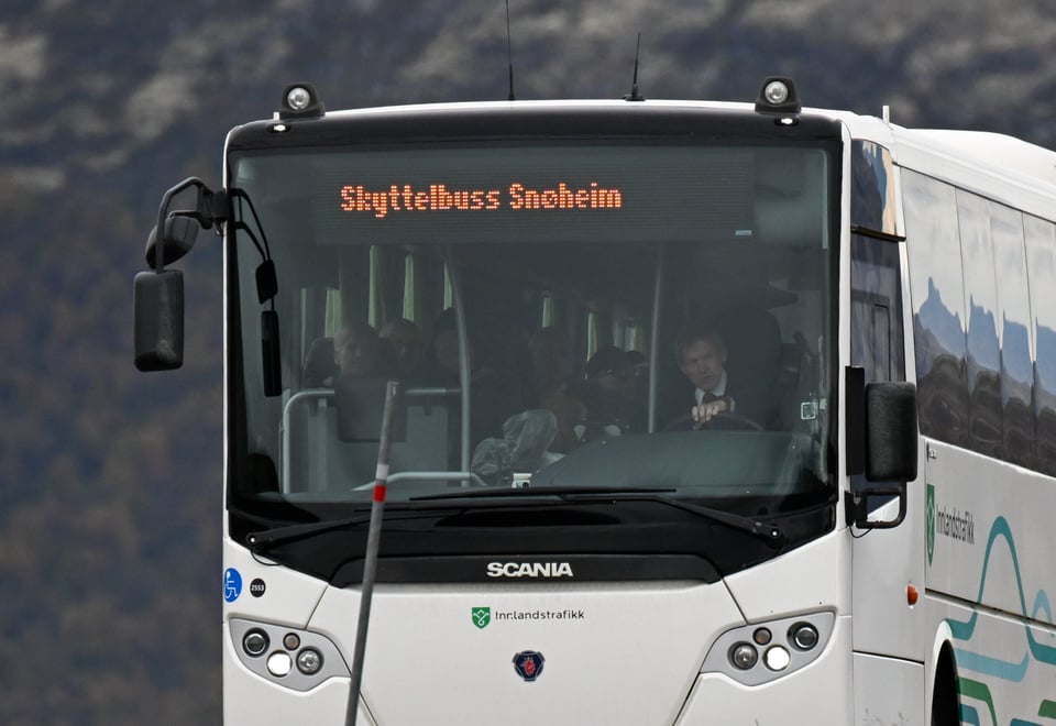 Hvit buss med tekst hvor det står Skyttelbuss Snøheim