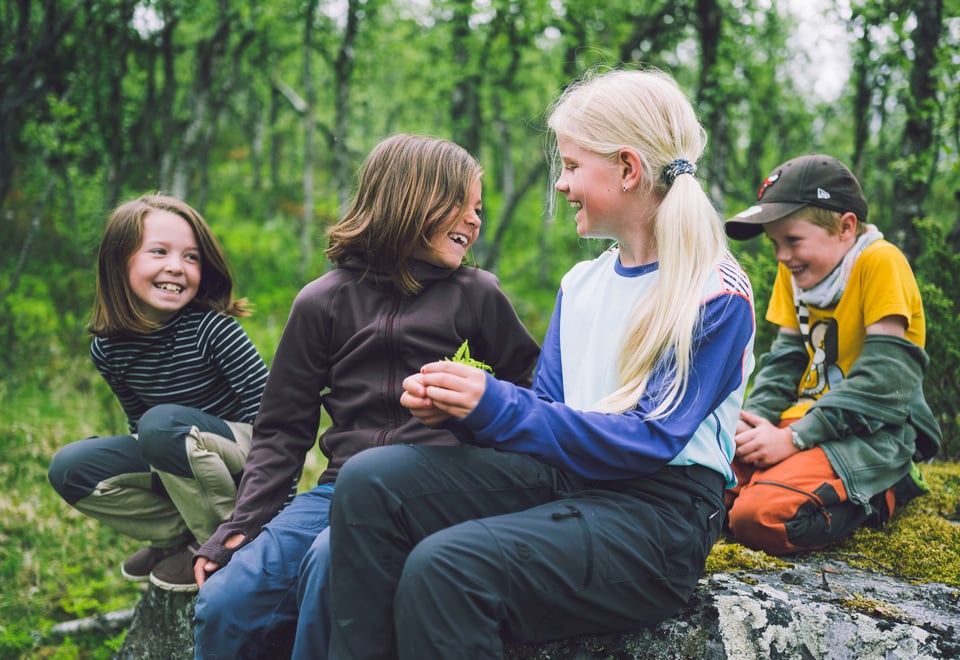 Barn som sitter i skog