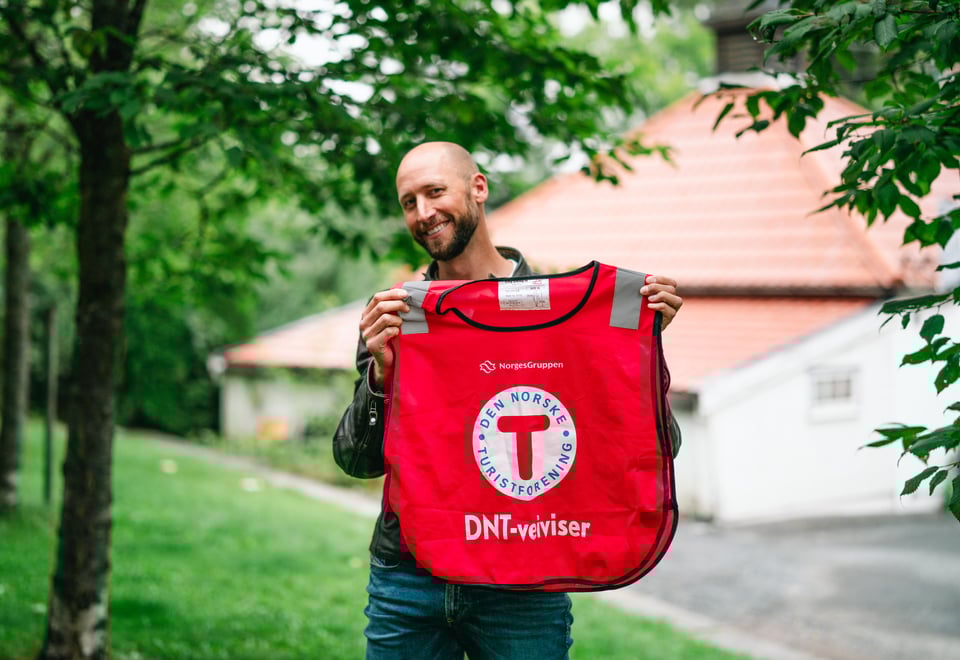 Person som holder opp en DNT-vest