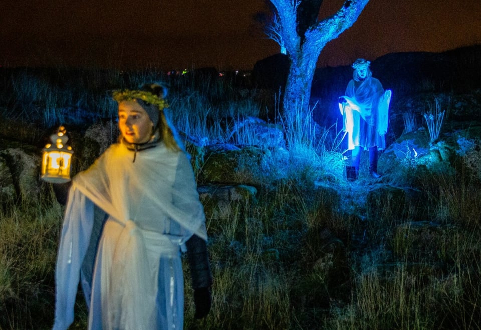 Jente i hvit kjole med stearinlys i natten