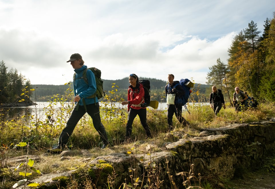 En gruppe ungdommer som går på en demning langs et vann i Oslomarka.