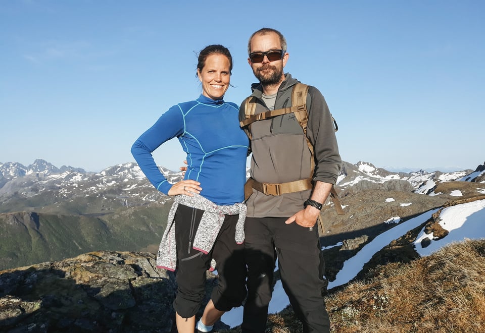 En smilende kvinne og mann på en fjelltopp.