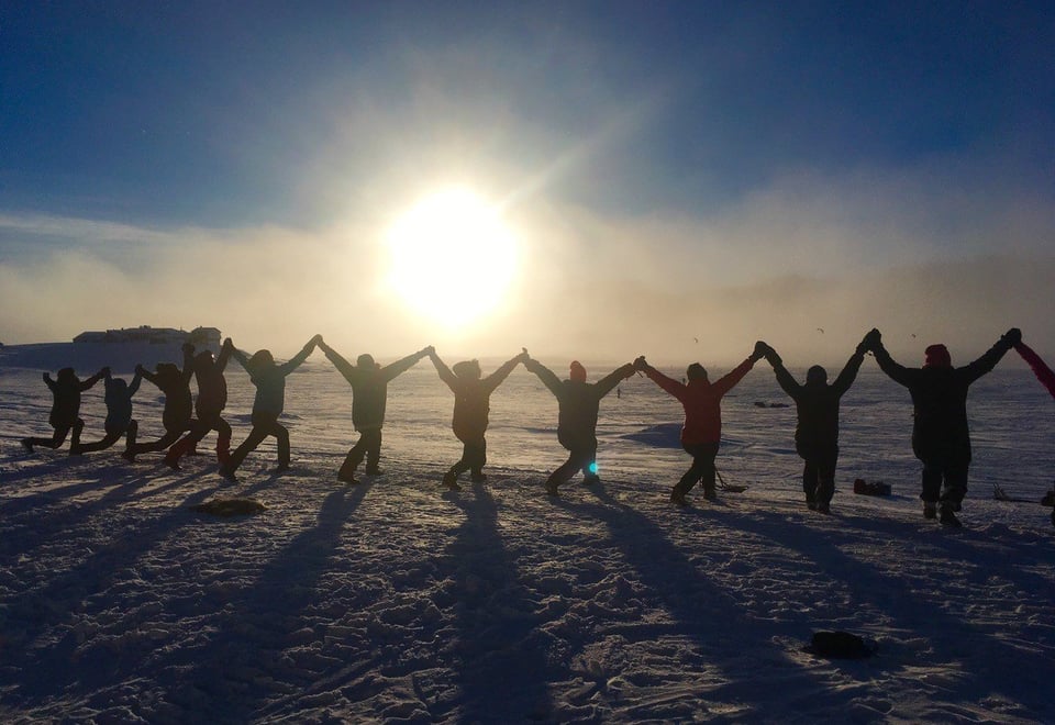 Silhuett av en rekke med mennesker som holder hender