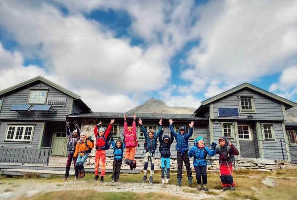 Glade turbarn foran hytte på fjellet