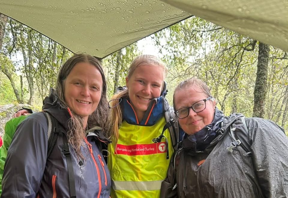 Tre frivillige smiler på kveldsmattur