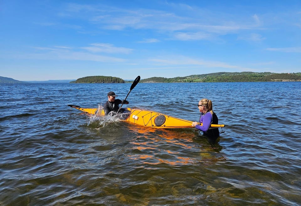 Bildet viser noen som øver på balanse i vann, kajakk.