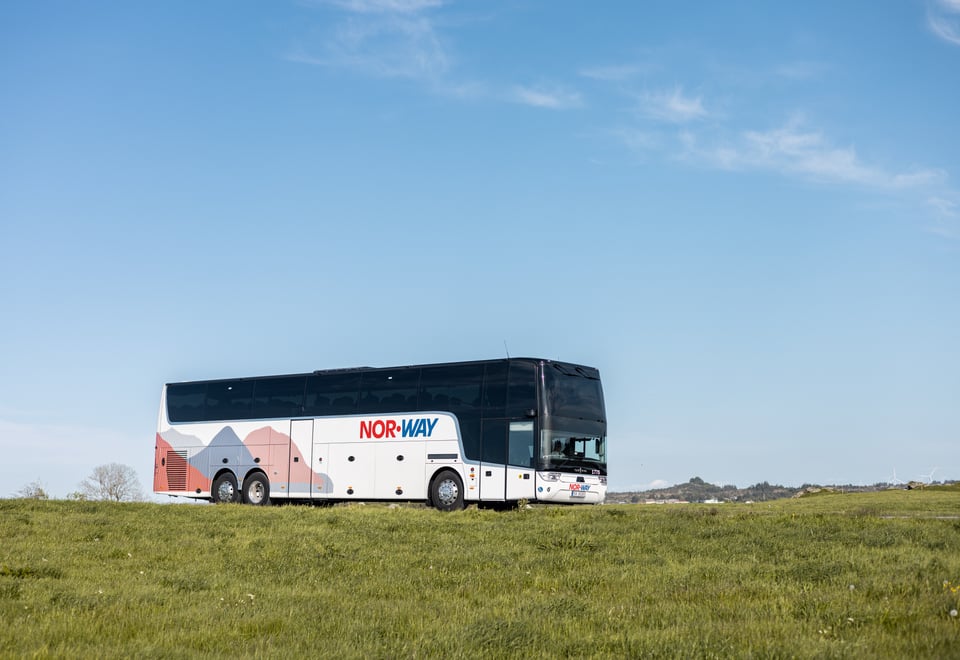 En buss som kjører i grønt landskap