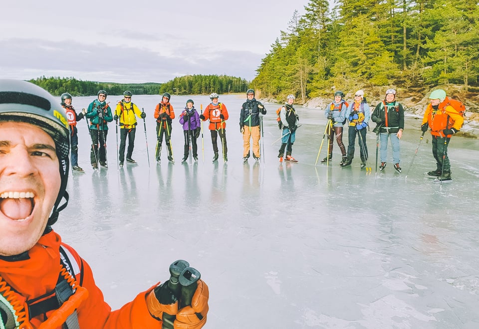 En gjeng turskøytere på isen, utstyrt med sekk, staver og hjelm.