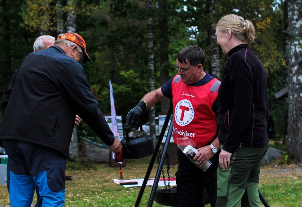 Mennesker står rundt bålpanne