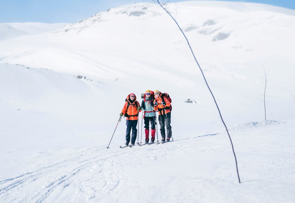 Tre personer med fjellski som går langs en kvistetløype