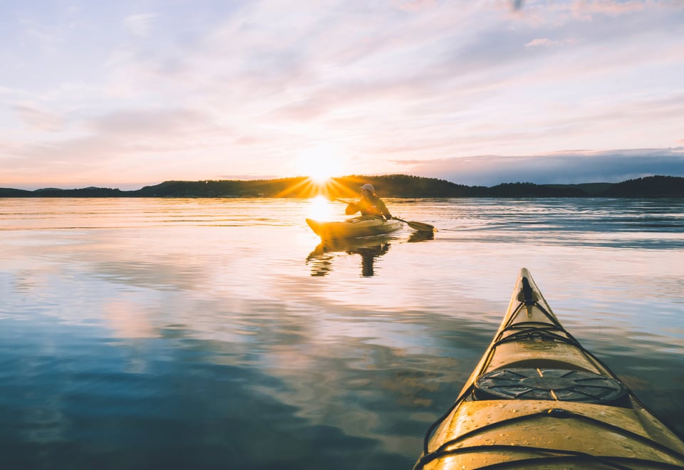 To kajakker på vannet i solnedgang.