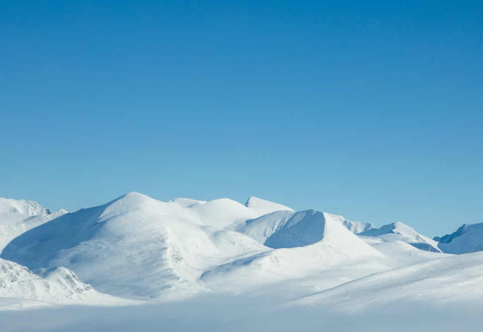 Snødekte fjelltopper og blå himmel