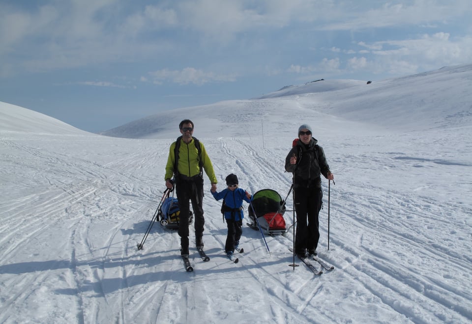 familie på ski, en med pulk.