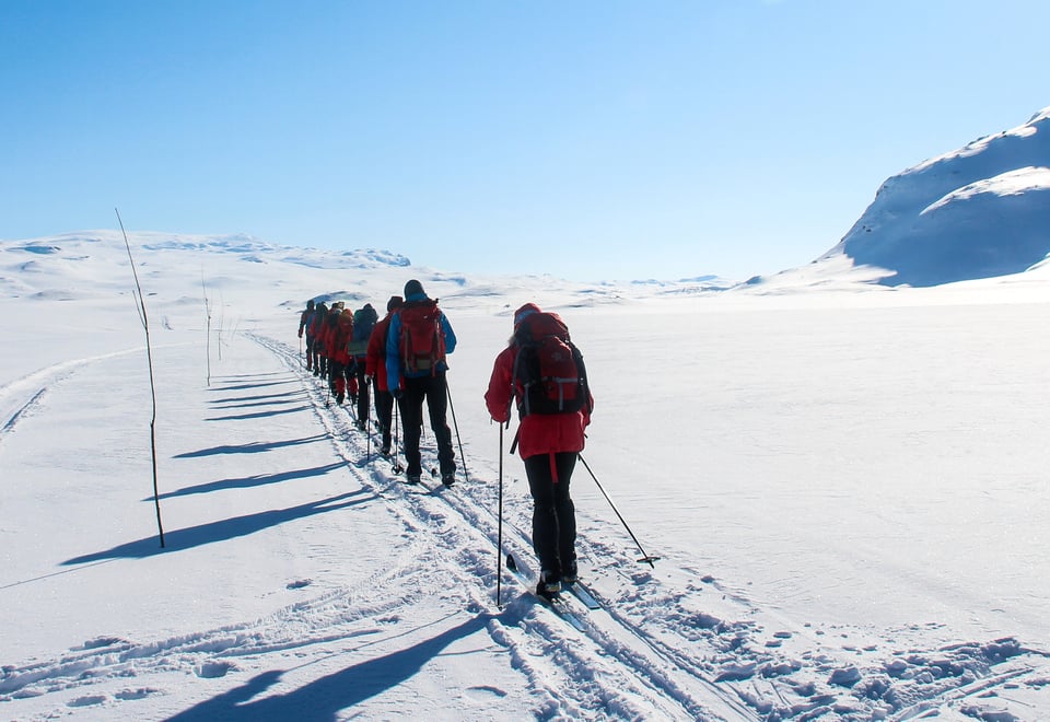 Flere personer som går på fjellski innover vinterfjellet