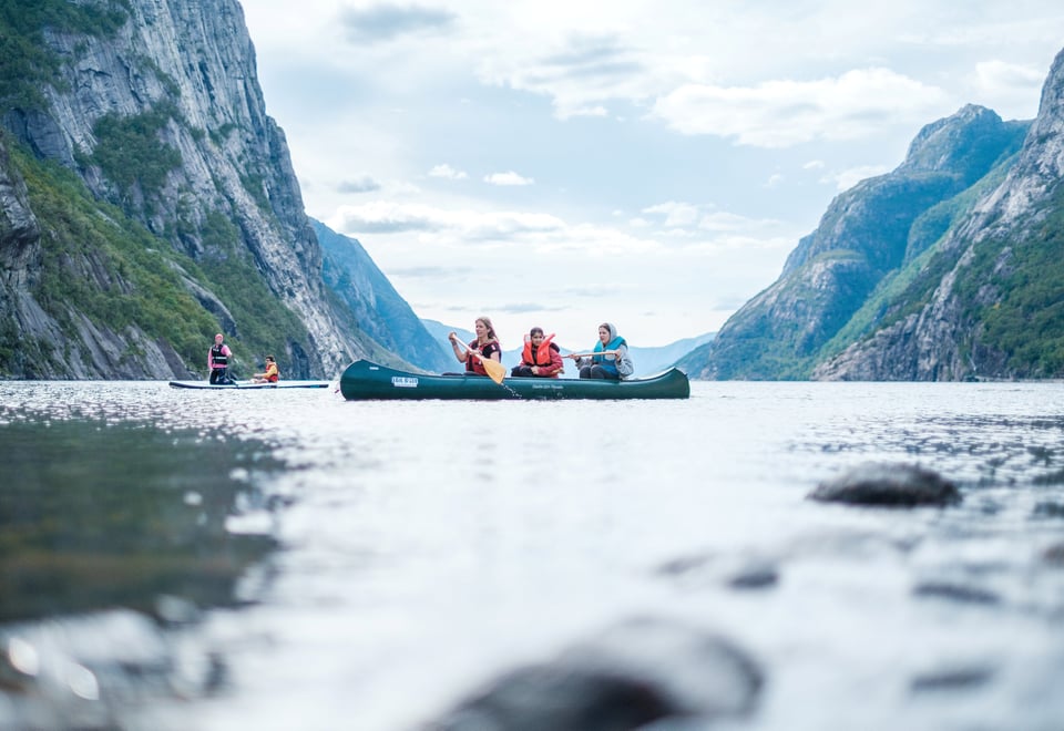 Tre personer i kano padlende i Lysefjorden.