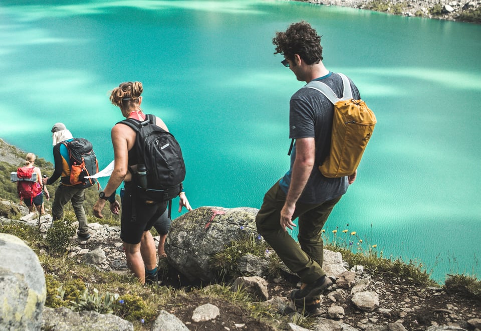 Fire personer som går ned en fjellside
