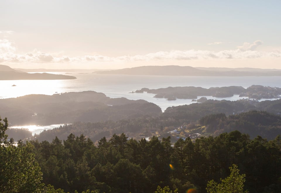 Utsikt over øyrike i Bjørnafjorden med sol, skyer og sjø.