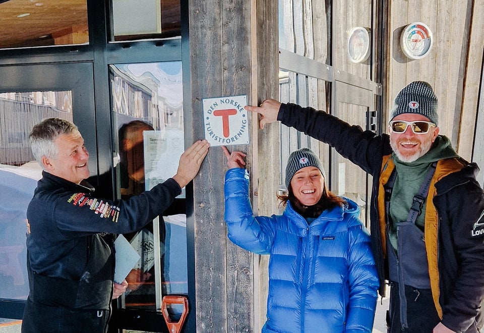 Inne i den lyse og levende resepsjonen på Leirvassbu står det en person bak skranken.