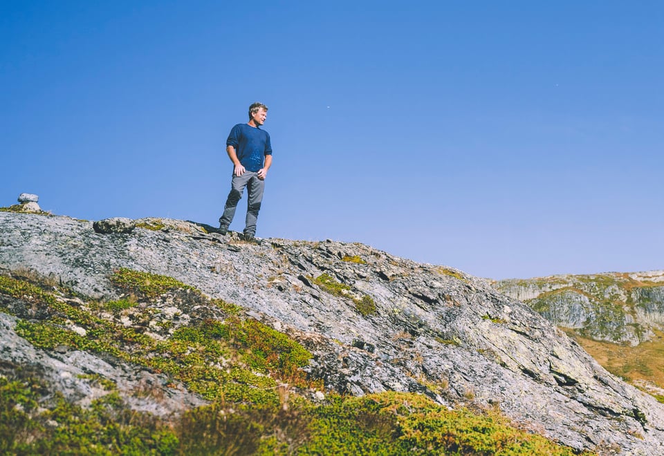 Bilde tatt med drone av en hytte i solskinn