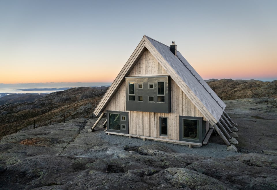 Hytte med skråtak på fjellplatå.
