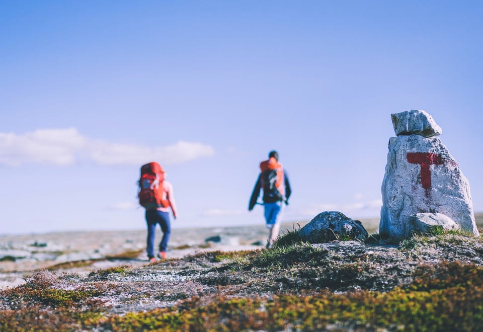 To turgåere i fjellet, stein med rød T