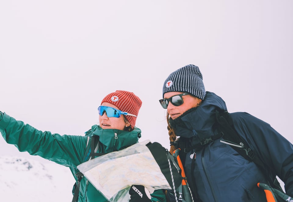 To kvinner ser på kart i vinterlandskap