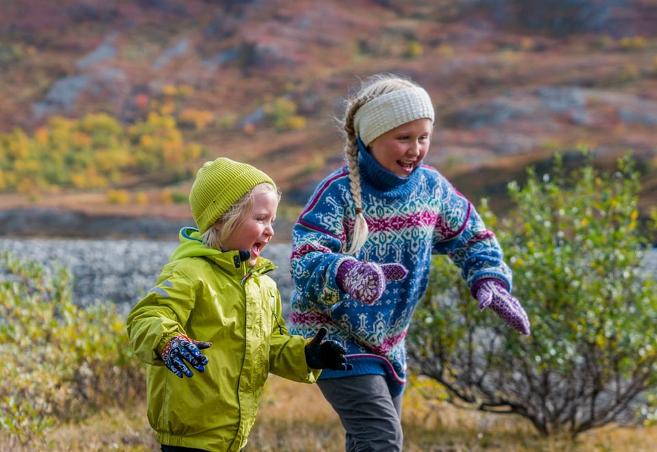 To glade barn løper ute i naturen