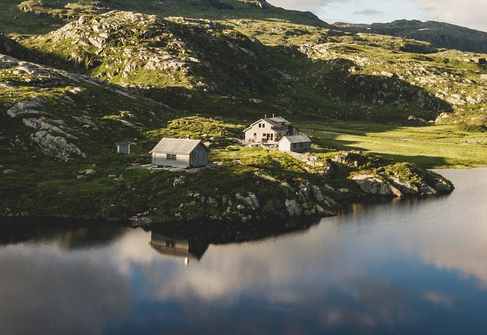Hytte i grønt landsskap ved fjellvann
