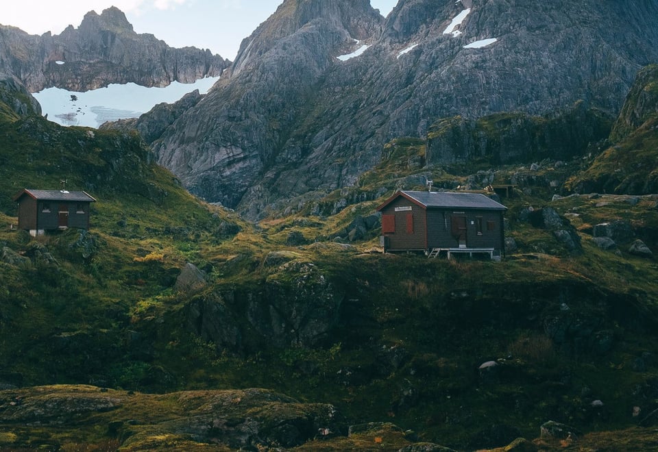 Hytte mellom høye fjell