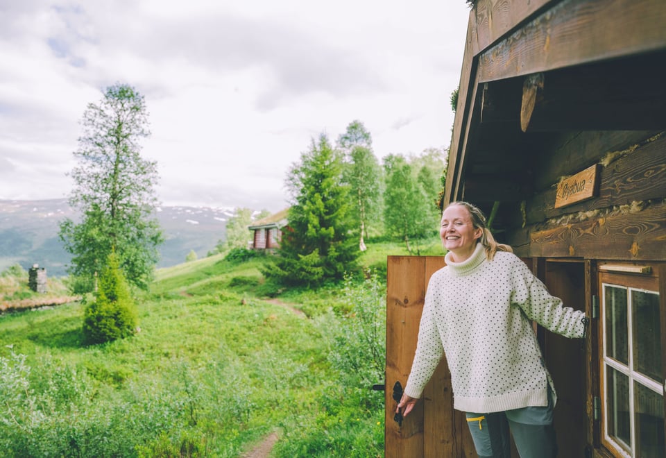 A woman opening a door in a cabin