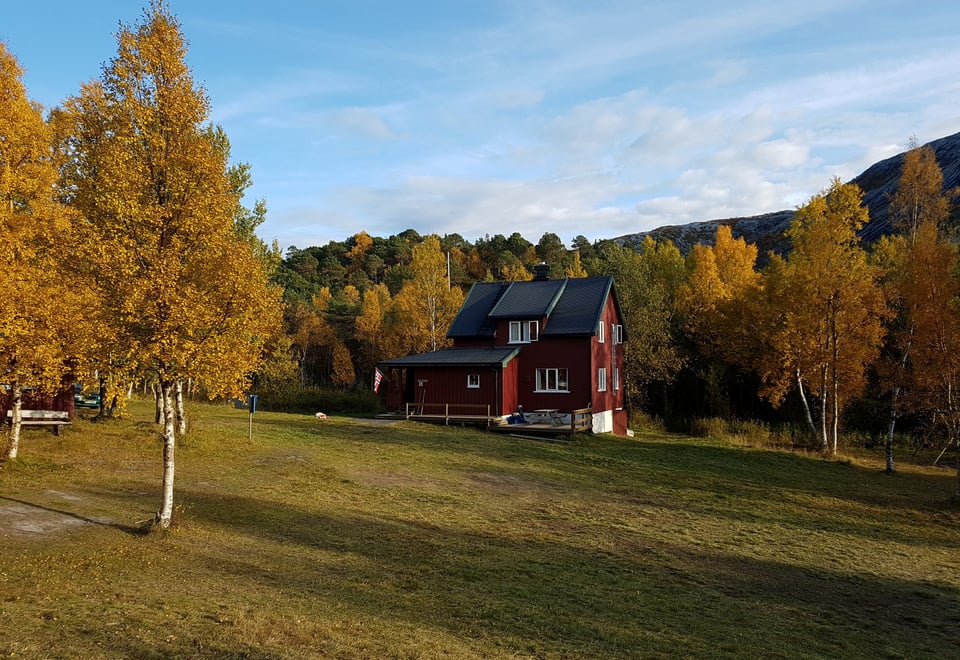 Gjælentunet - hovedhuset med flotte høstfarger i skogen rundt