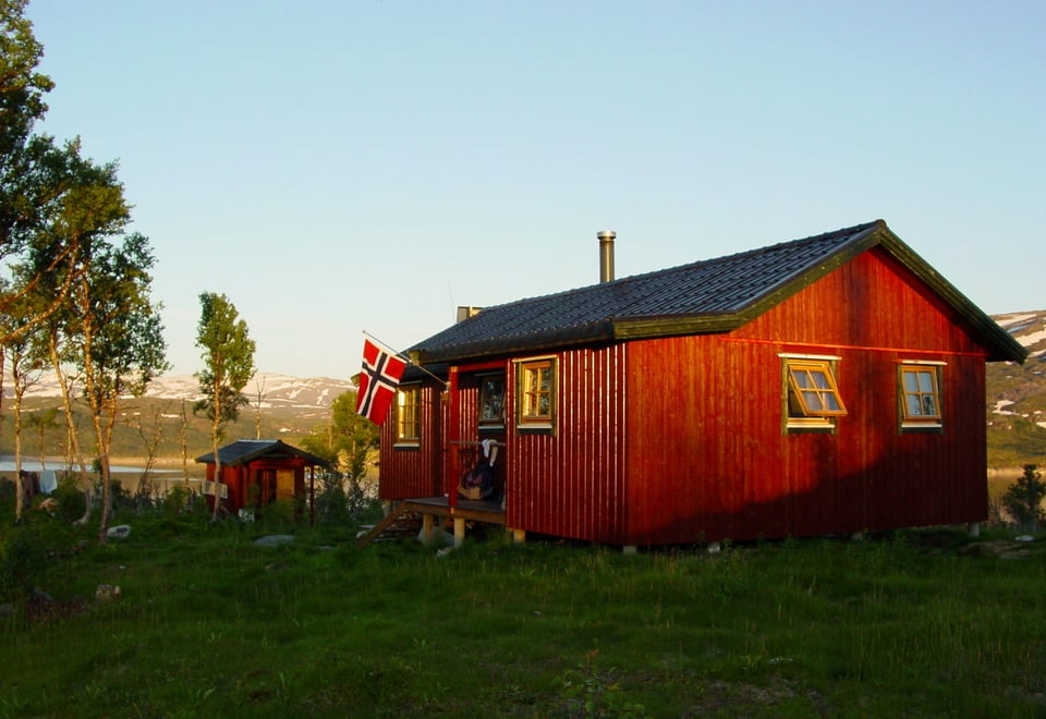 DNT hytta Fellvasstua i solnedgang i sommerlige omgivelser.
