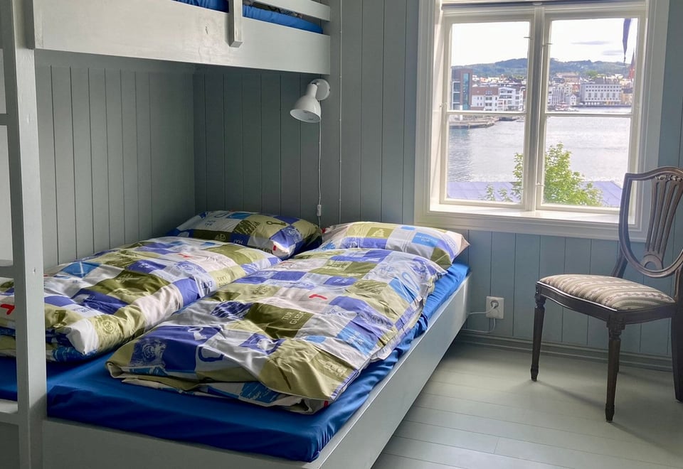 En rom med vindu og dobbeltseng. Foto. 